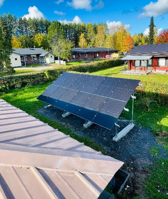 Aurinkopaneelit asennettuna pihamaalle